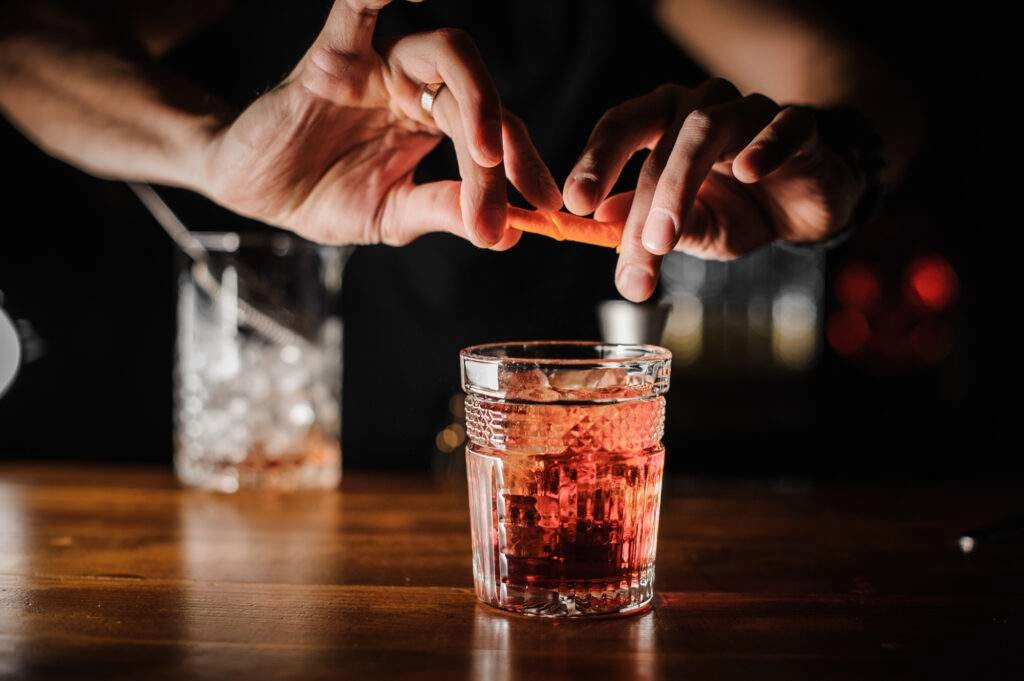 Un barman préparant un cocktail Negroni